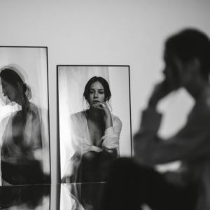 Woman looking at her reflection in mirrors, representing cognitive behavioral therapy skills for managing thoughts, emotions, and behaviors, with cognitive behavioral therapy available at Brite Recovery.
